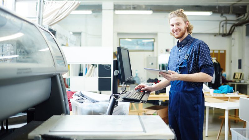Portrait of man doing orders of his clients on printing machine
