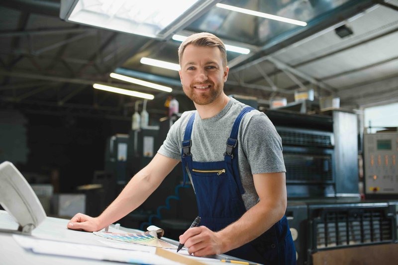 Funny portrait of typographer standing with color swatches at the printing manufacturing.